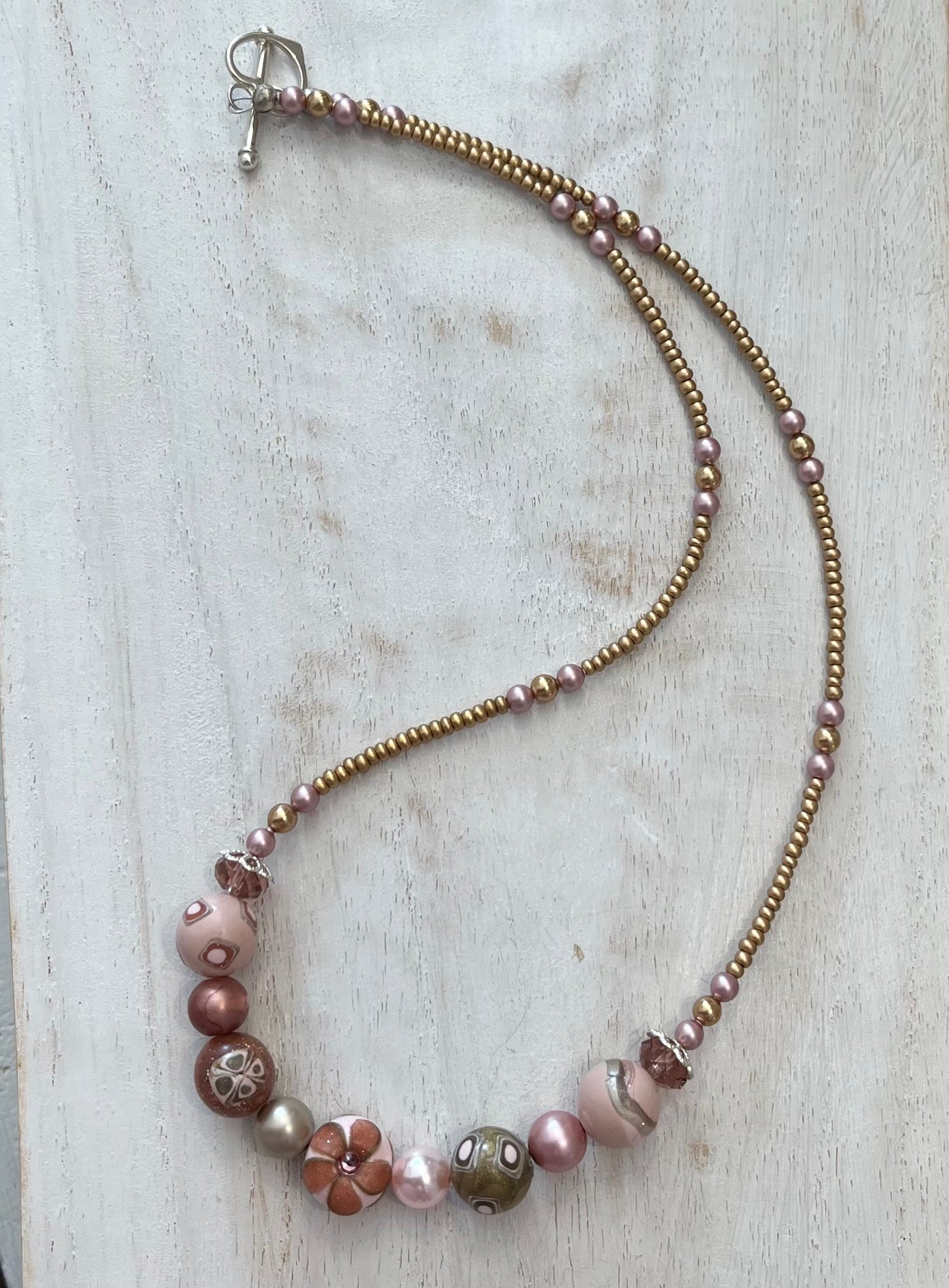 Handmade necklace by Stephanie Fraselle featuring sculpted rose-toned beads, Swarovski pearls, sterling silver, and a heart clasp, inspired by the Queen of Cups archetype.