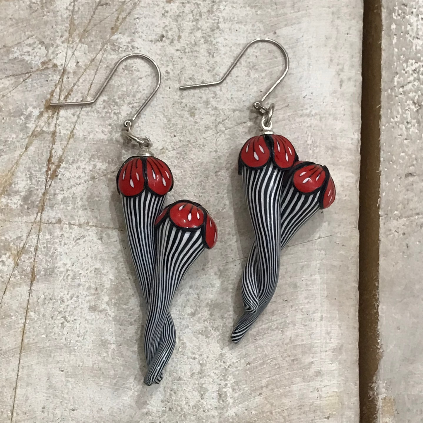 Handmade black and white pinstripe Soul Mates earrings by Lanzarote artisan Stephanie Fraselle with polymer clay flowers and sterling silver accents