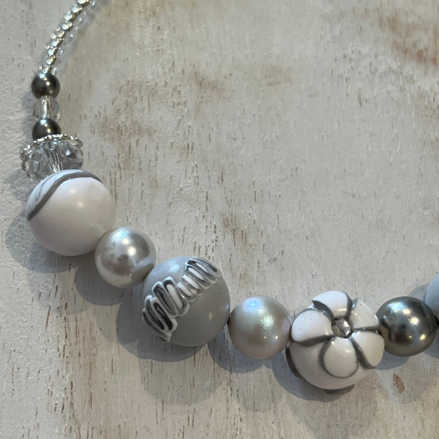 White Blossom Necklace by Stephanie Fraselle with five sculpted polymer clay beads in soft white and grey, accented by Swarovski crystals, pearls, and sterling silver clasp