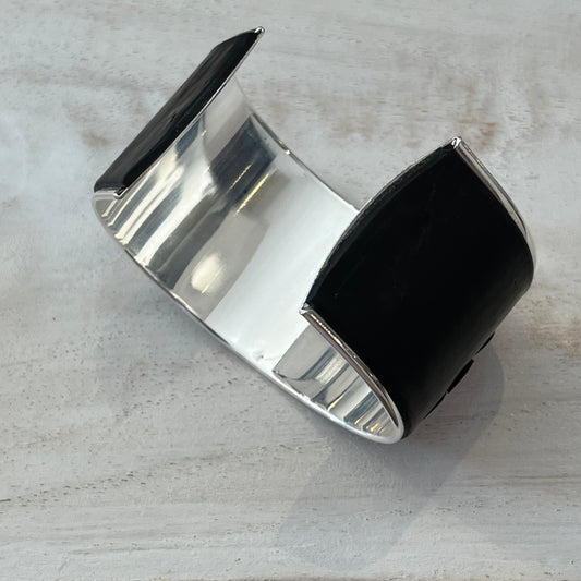 Unique handmade cuff by Lanzarote artisan Stephanie Fraselle featuring bold red and white floral accents on matte black polymer clay with silver-plated brass base