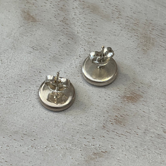 Close-up of mosaic stud earrings handcrafted by Stephanie Fraselle with pale pink, blush, gold, pearl tones and sterling silver settings.