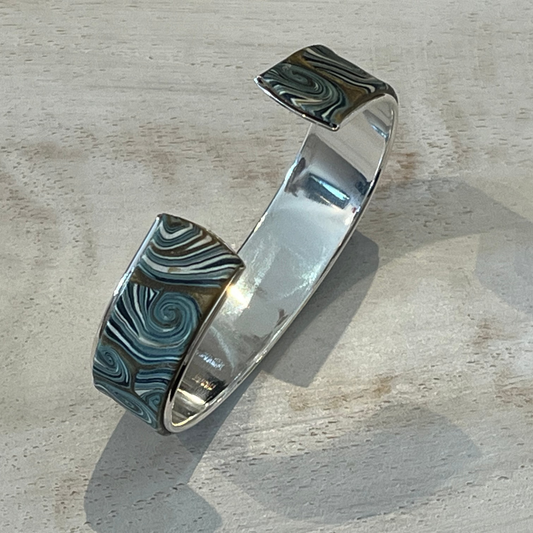 Handcrafted Nocturne cuff by Stephanie Fraselle in sterling silver-coated brass with gold, pearlescent, and petrol blue tones