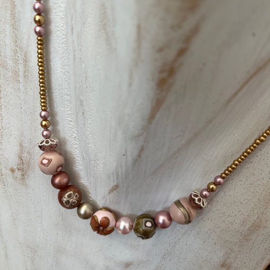 Handmade necklace by Stephanie Fraselle featuring sculpted rose-toned beads, Swarovski pearls, sterling silver, and a heart clasp, inspired by the Queen of Cups archetype.