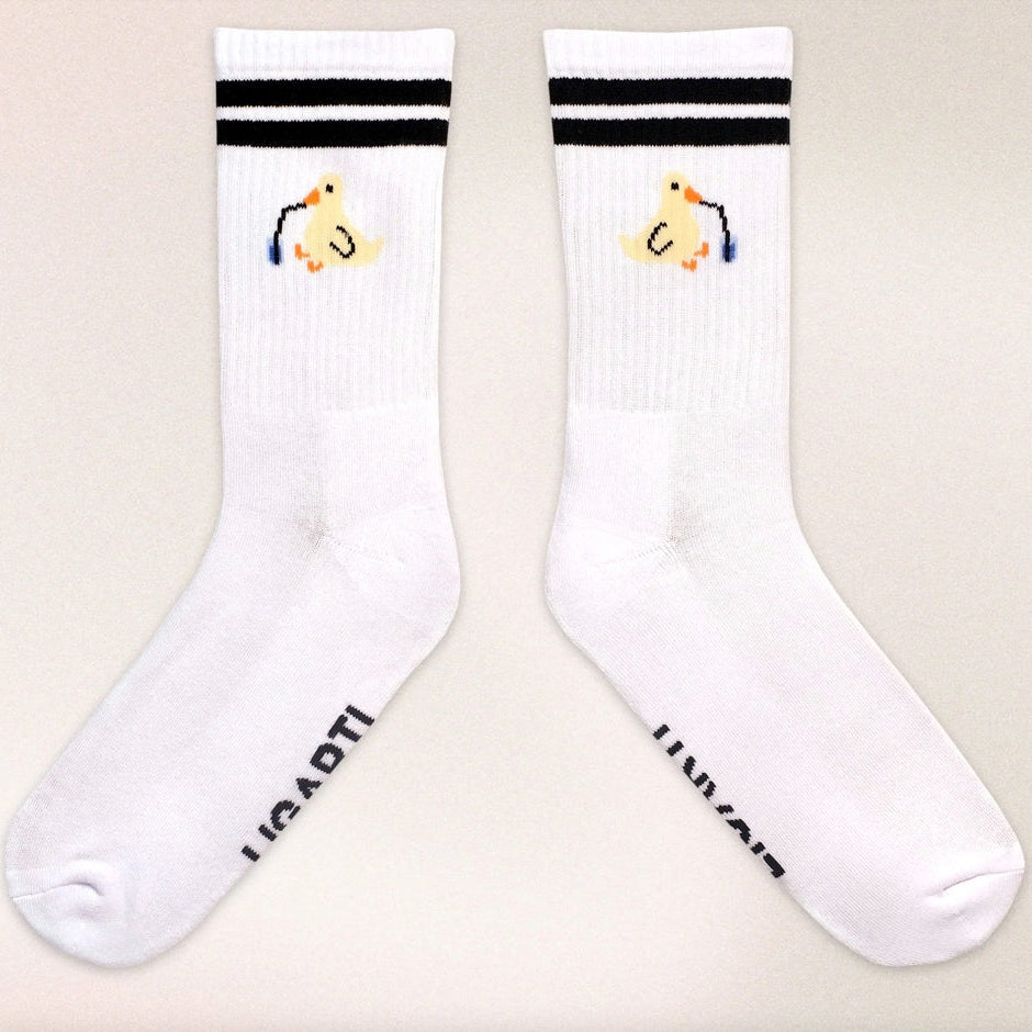 Minimalist cotton socks featuring Piet the Sippy Duck sipping from a cup with a straw, inspired by Hanna’s artwork