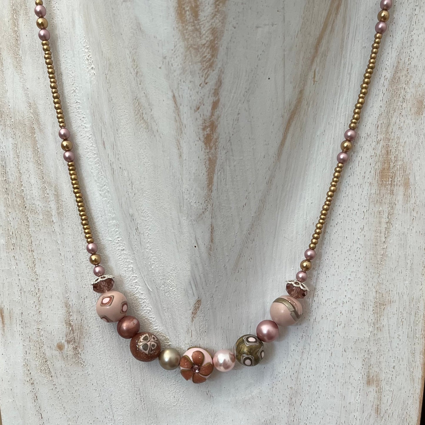 Handmade necklace by Stephanie Fraselle featuring sculpted rose-toned beads, Swarovski pearls, sterling silver, and a heart clasp, inspired by the Queen of Cups archetype.