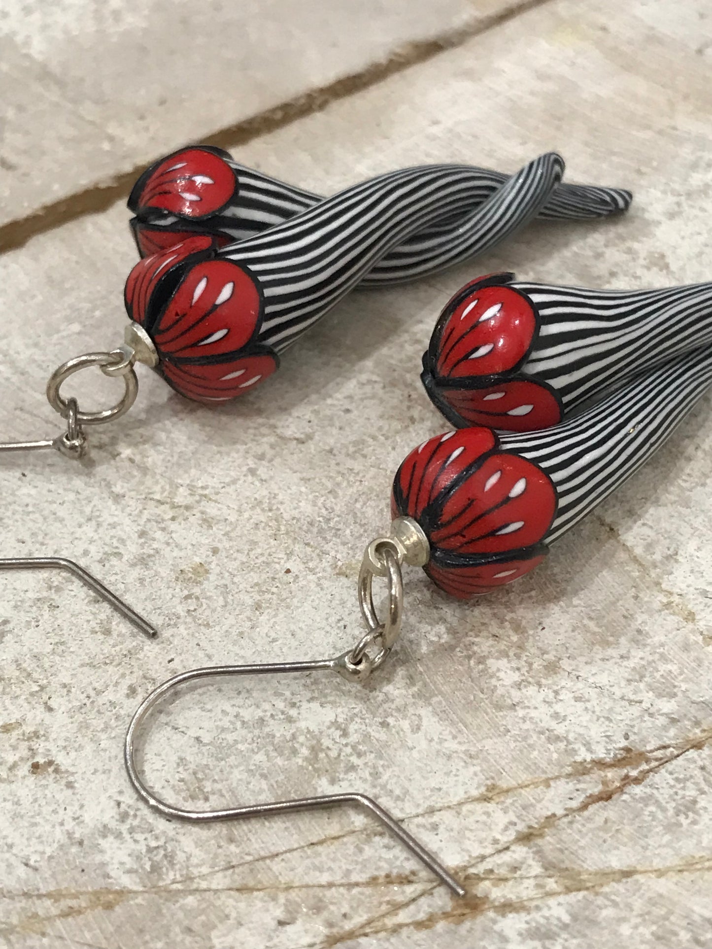 Handmade black and white pinstripe Soul Mates earrings by Lanzarote artisan Stephanie Fraselle with polymer clay flowers and sterling silver accents