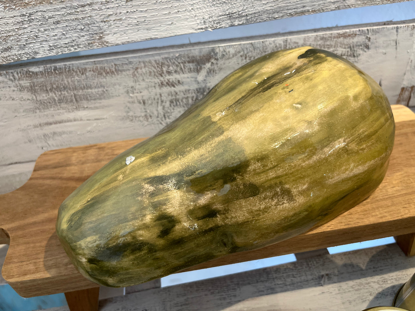 Hyperreal ceramic sculpture of halved papaya with glistening seeds in lifelike detail
