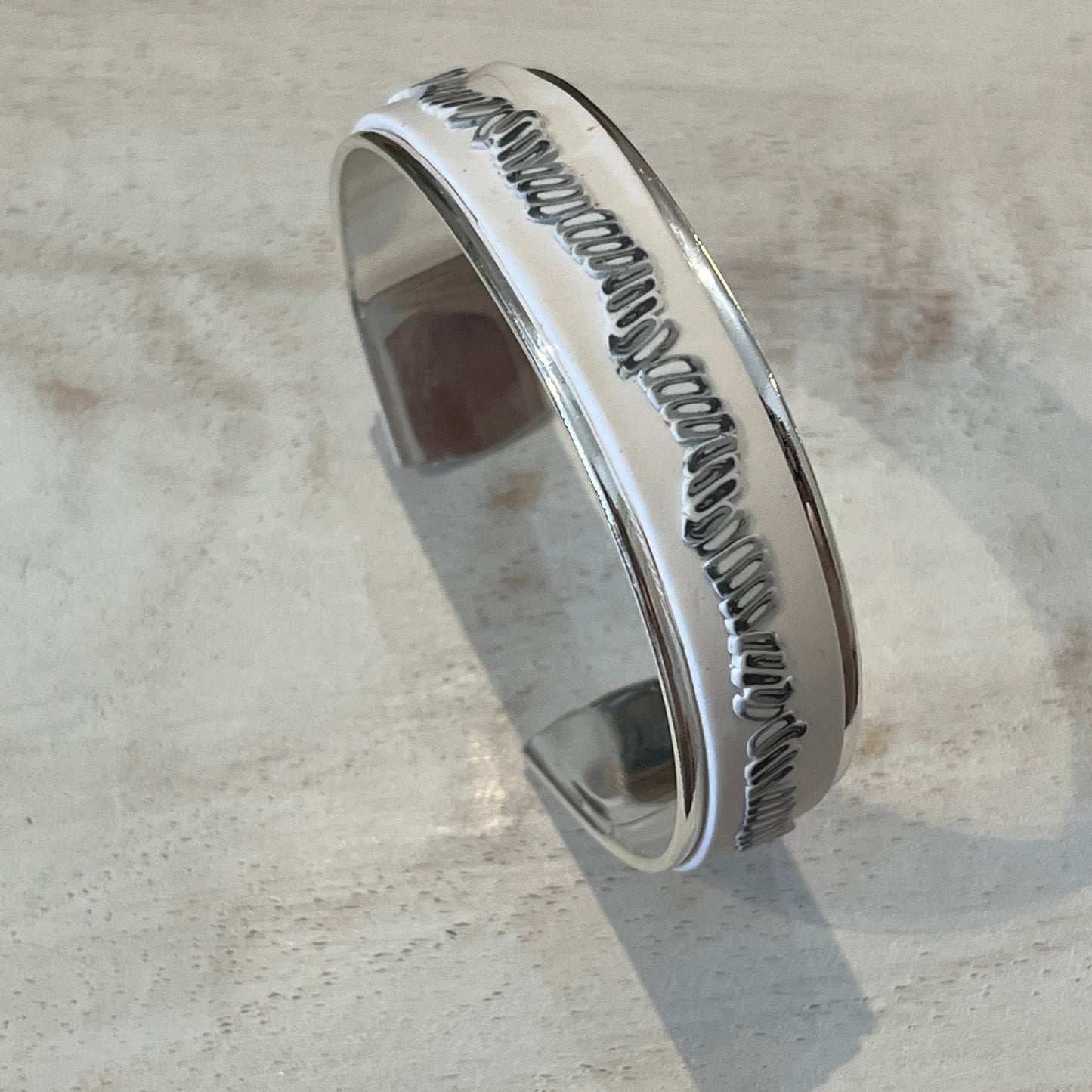 White Blossom Mosaic Cuff by Stephanie Fraselle featuring a matte white band and a linear mosaic of grey and white tiles, handcrafted from polymer clay with slight adjustability and a sterling silver-plated finish.