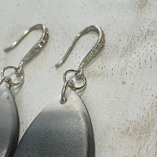Close-up of handcrafted Moonlit Shimmer mismatched silver and polymer clay drop earrings with pearlescent finish