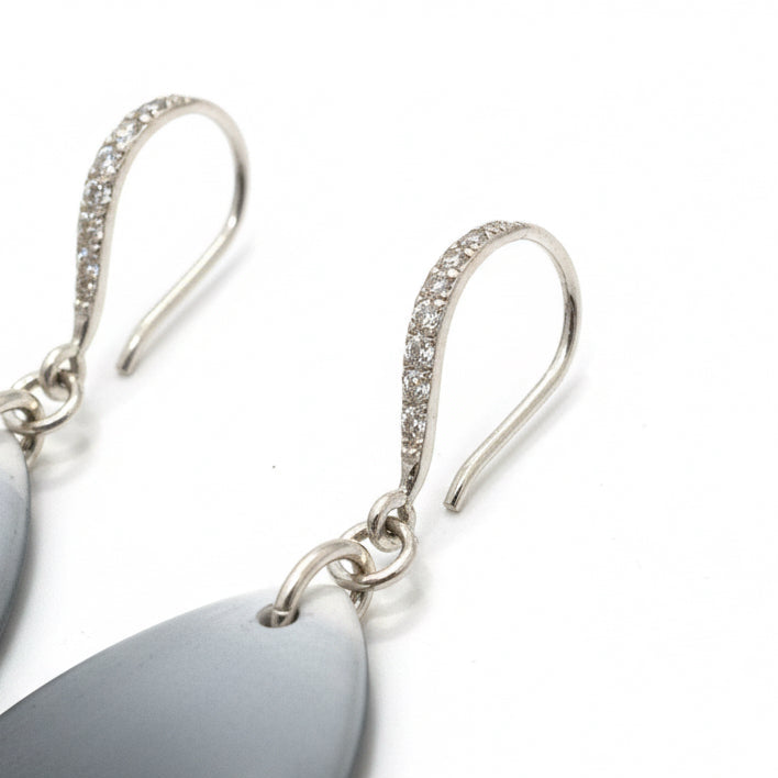 Close-up of handcrafted Moonlit Shimmer mismatched silver and polymer clay drop earrings with pearlescent finish