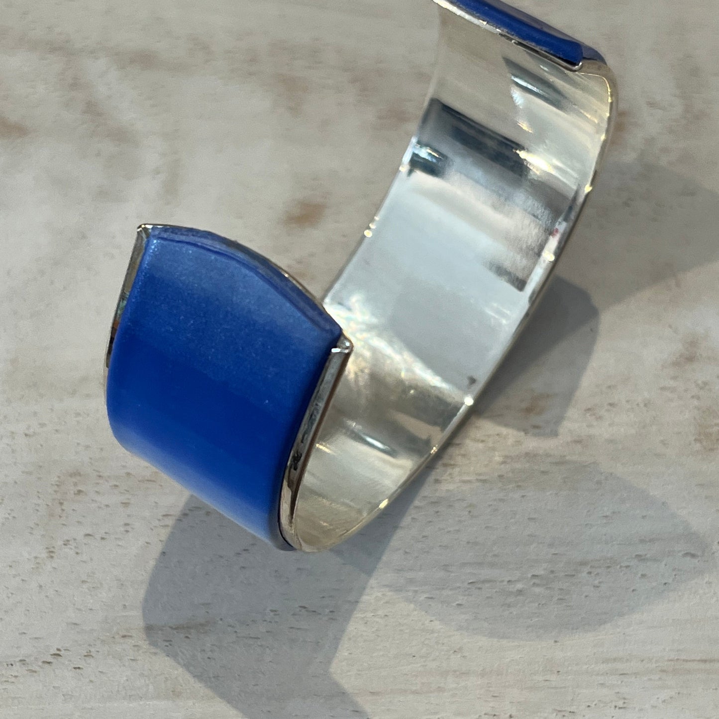 Handcrafted polymer clay cuff in sapphire blue, navy, ultramarine, and pearl white from Stephanie Fraselle’s Ocean Shimmer Collection.