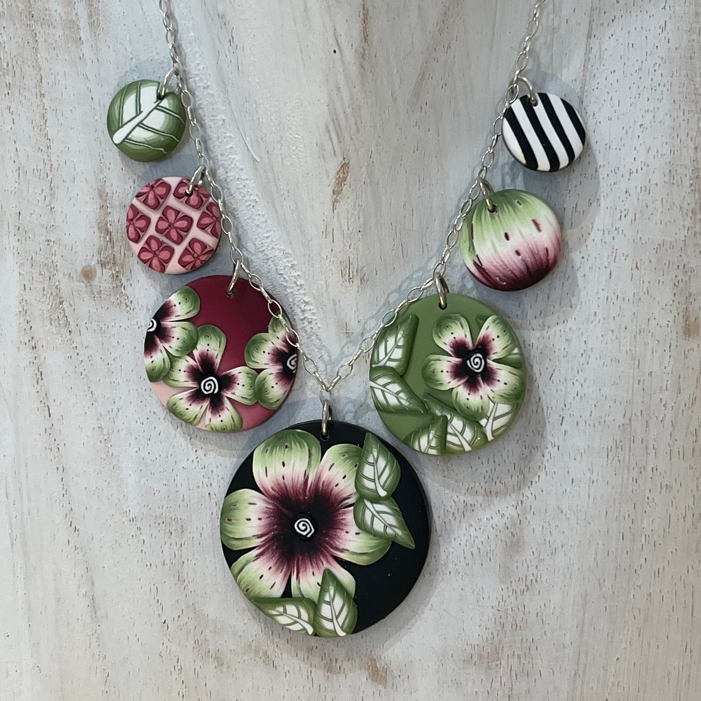 Handcrafted seven-medallion floral necklace in layered polymer clay with watercolour petals and sterling silver chain by Stephanie Fraselle