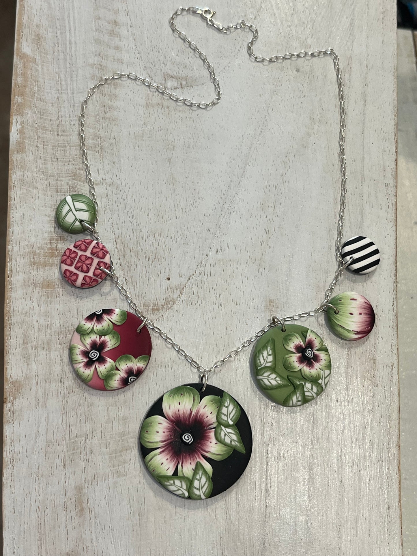 Handcrafted seven-medallion floral necklace in layered polymer clay with watercolour petals and sterling silver chain by Stephanie Fraselle