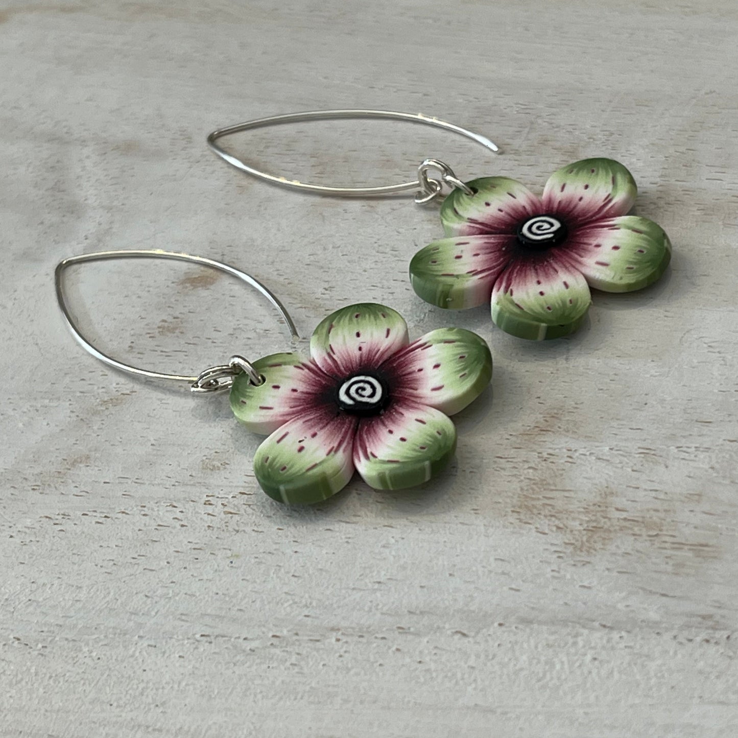 Lightweight polymer clay floral earrings with watercolor-blended petals in crimson, pink, black, and sage, on sterling silver drops by Stephanie Fraselle
