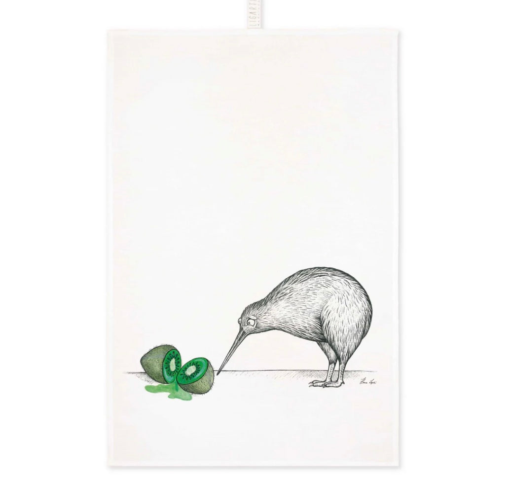 Black and white kiwi bird illustration looking at a colourful watercolour of a sliced green kiwi fruit on a linen tea towel