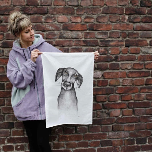 Illustration of a dog with a devoted, soulful expression printed on a linen tea towel