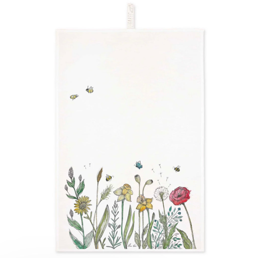 Colourful illustration of a wildflower meadow with bees printed on a linen tea towel