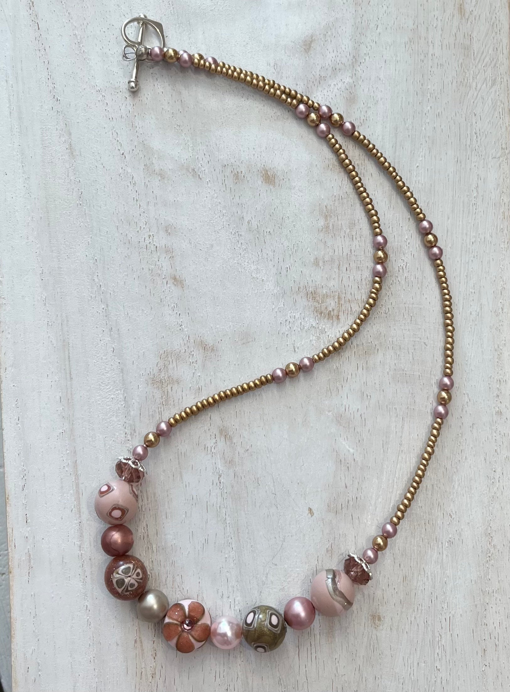 Handmade necklace by Stephanie Fraselle featuring sculpted rose-toned beads, Swarovski pearls, sterling silver, and a heart clasp, inspired by the Queen of Cups archetype.