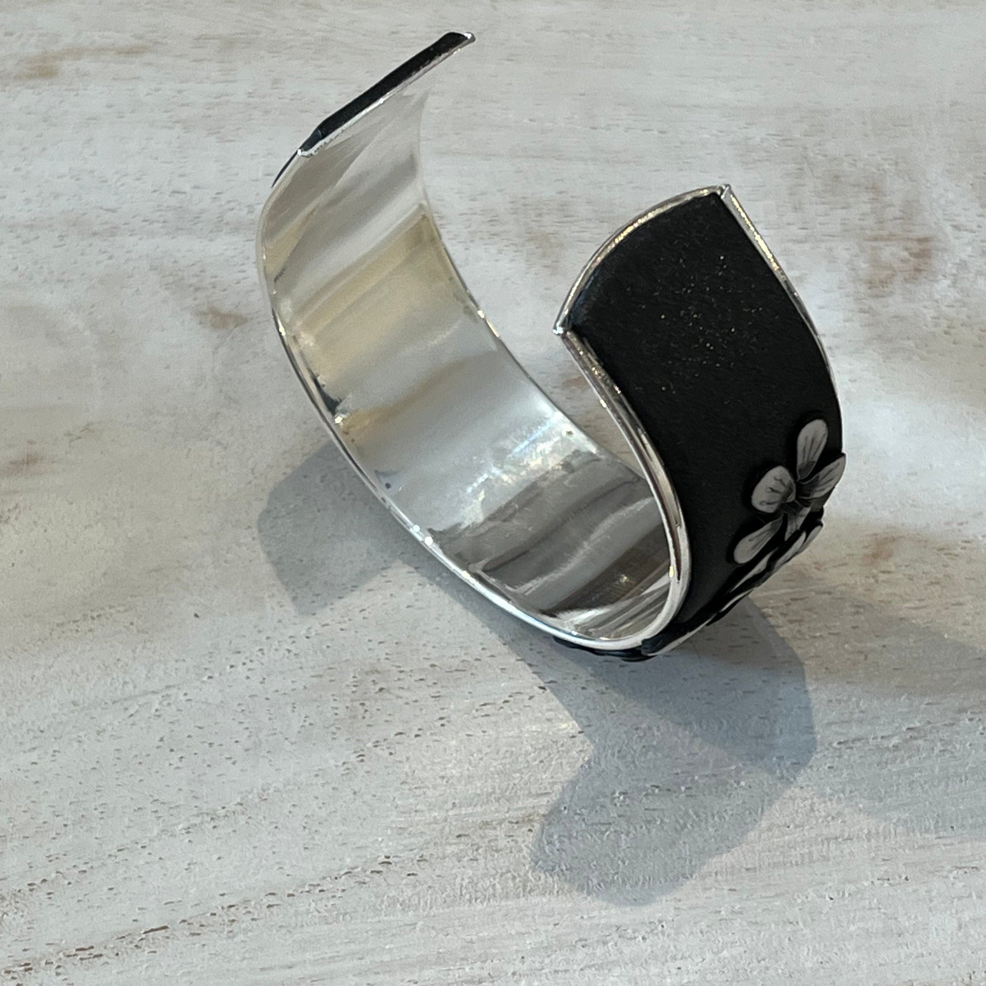 Moonlit Shimmer Blossom Cuff by Stephanie Fraselle featuring polymer clay florals and Swarovski crystals, handcrafted in Lanzarote