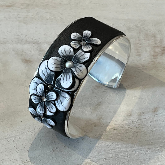 Moonlit Shimmer Blossom Cuff by Stephanie Fraselle featuring polymer clay florals and Swarovski crystals, handcrafted in Lanzarote