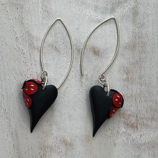 Handcrafted black heart-shaped earrings with red flower detail by Lanzarote artisan Stephanie Fraselle, paired with matching pendant (sold separately)