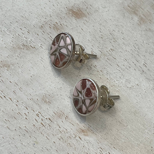 Close-up of mosaic stud earrings handcrafted by Stephanie Fraselle with pale pink, blush, gold, pearl tones and sterling silver settings.