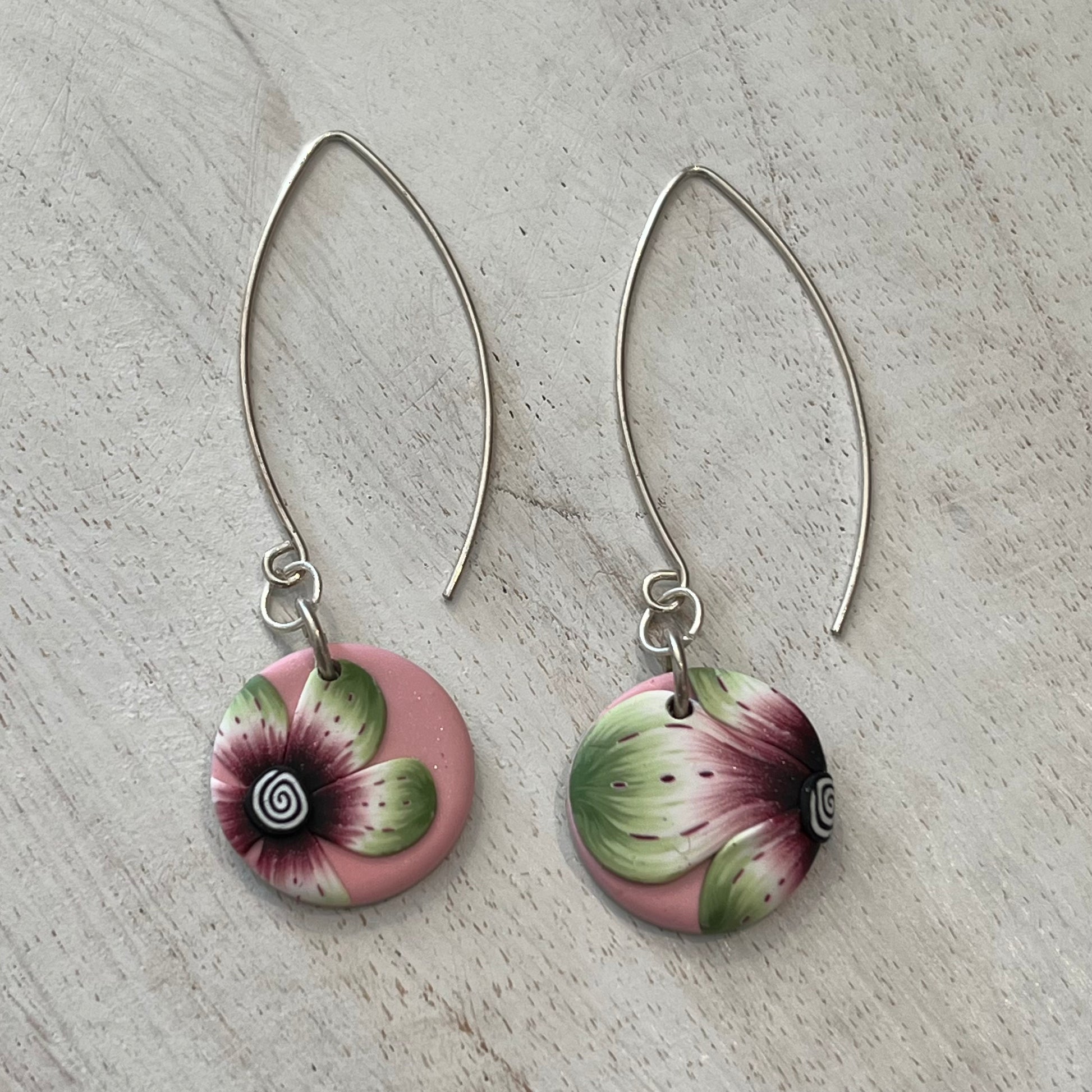 Handmade polymer clay medallion earrings by Stephanie Fraselle featuring watercolor-inspired floral design on pale pink background