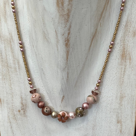 Handmade necklace by Stephanie Fraselle featuring sculpted rose-toned beads, Swarovski pearls, sterling silver, and a heart clasp, inspired by the Queen of Cups archetype.