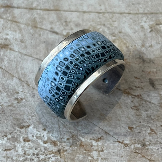 Handcrafted petrol blue and grey shimmer polymer clay mosaic ring from the Sea Foam Series, inspired by ocean waves and organic cellular patterns; adjustable sterling silver–plated brass band fits sizes 54mm–62mm; artisan jewelry with marine and geological textures for a unique, ocean-inspired statement piece.