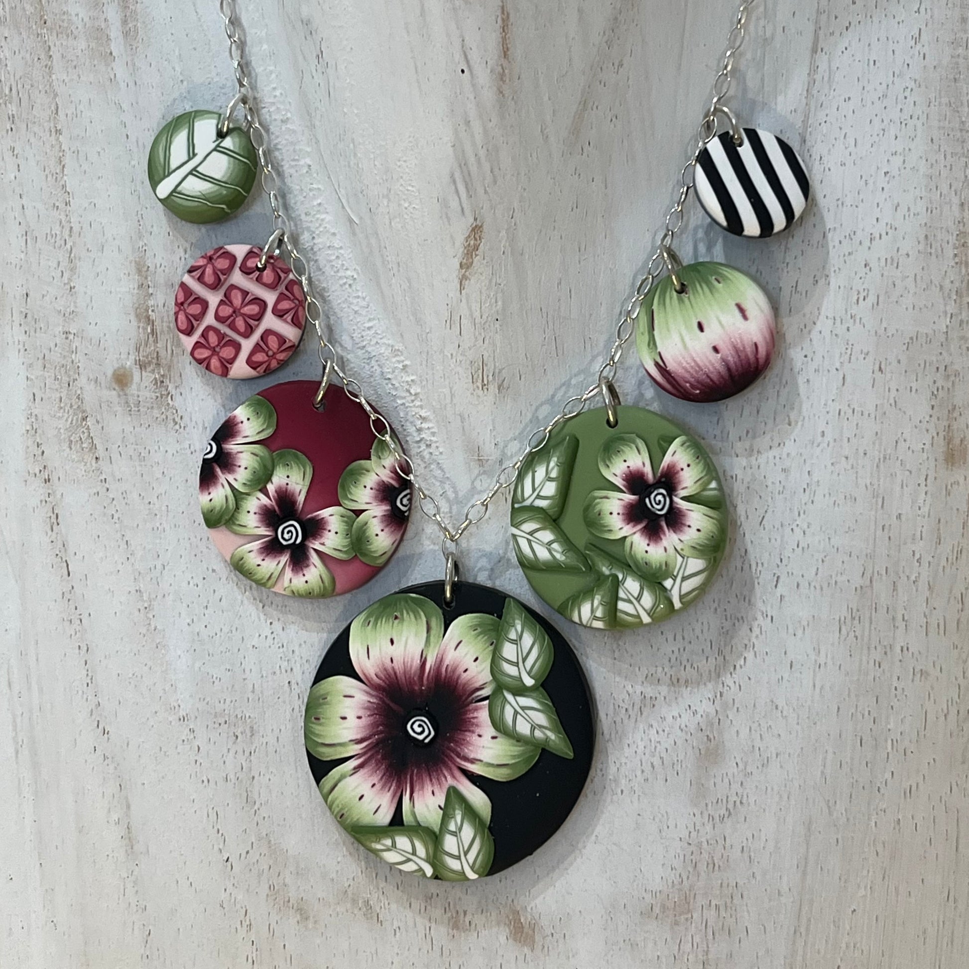 Handcrafted seven-medallion floral necklace in layered polymer clay with watercolour petals and sterling silver chain by Stephanie Fraselle
