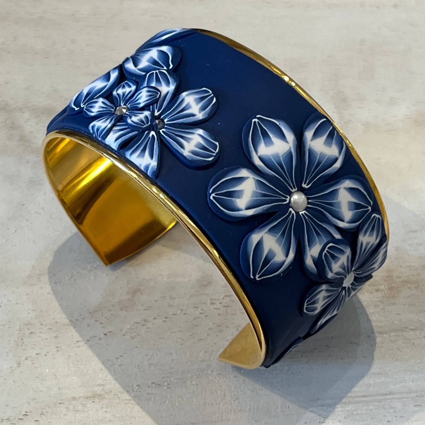 Midnight Navy Bloom Cuff by Stephanie Fraselle, featuring hand-sculpted polymer clay florals, Swarovski pearls, and 24k gold-plated brass