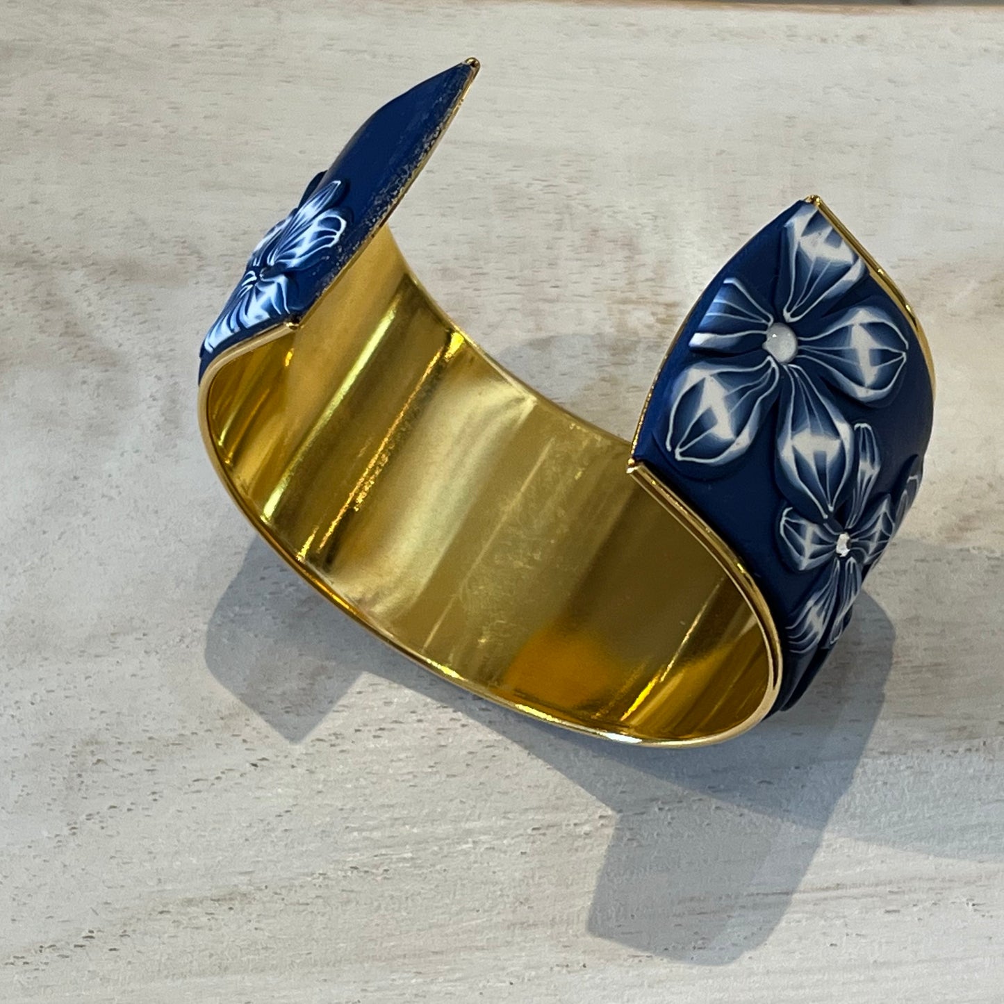 Midnight Navy Bloom Cuff by Stephanie Fraselle, featuring hand-sculpted polymer clay florals, Swarovski pearls, and 24k gold-plated brass