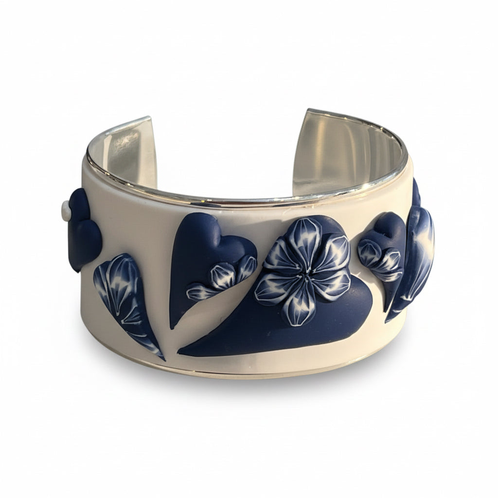 Hand-sculpted navy and white love heart bracelet cuff in polymer clay by Stephanie Fraselle, featuring raised heart motifs and silver-plated interior.