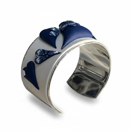 Hand-sculpted navy and white love heart bracelet cuff in polymer clay by Stephanie Fraselle, featuring raised heart motifs and silver-plated interior.